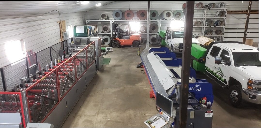 Inside the Steel Master roll-forming shop in Goshen, Indiana. Panels being fabricated on the shop floor with the Steel Master truck parked at the loading bay