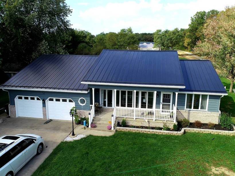 Ranch home in Fort Wayne, Indiana with a navy metal roof and a covered porch