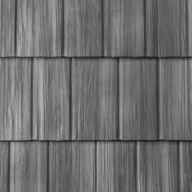 Close-up of stamped steel shake shingles showing the woodgrain shadow line